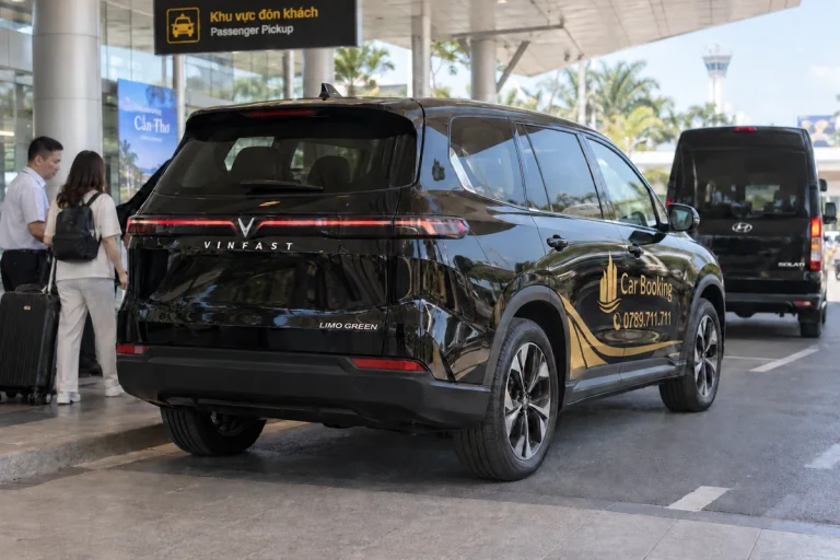 空港の乗車エリアで後方から見た黒いCar Bookingの車。