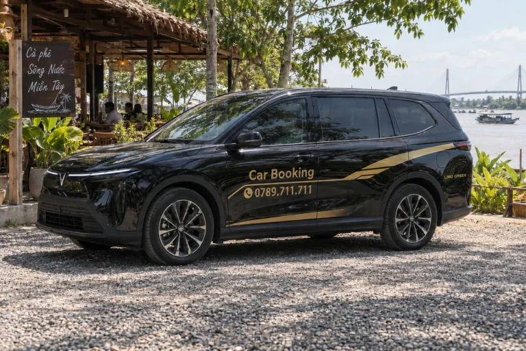 木陰の休憩施設に停まる黒いCar Bookingの車の側面。