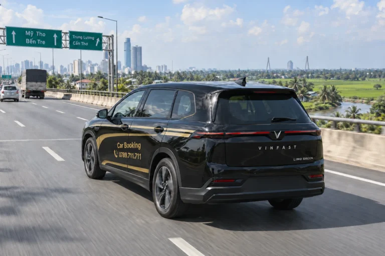 Xe Car Booking nhìn từ phía sau trên tuyến đường qua đồng bằng sông Cửu Long.
